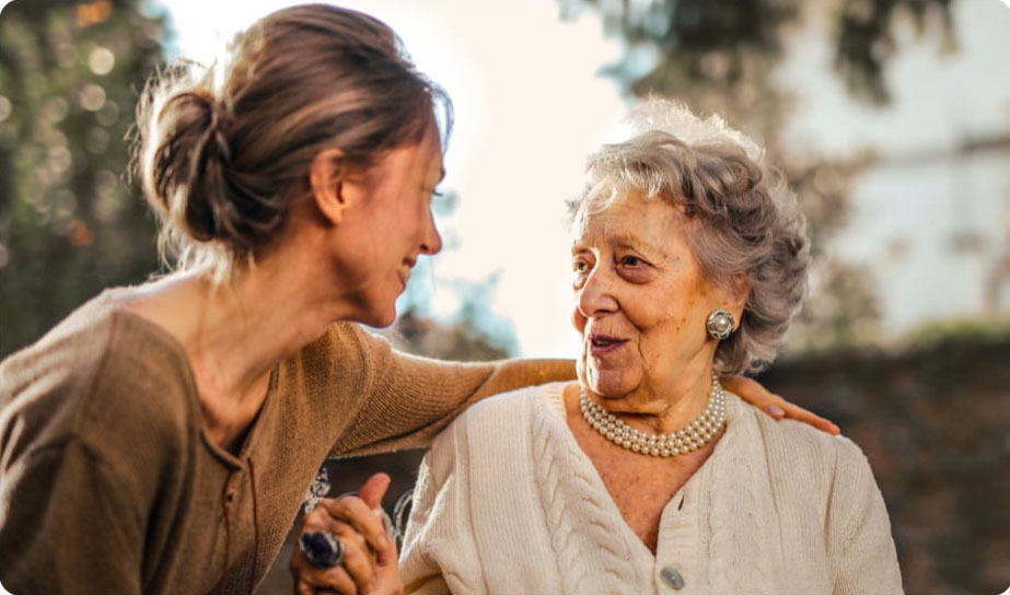 Une femme âgée et une femme d'âge mur se regardent avec bienveillance et gratitude
